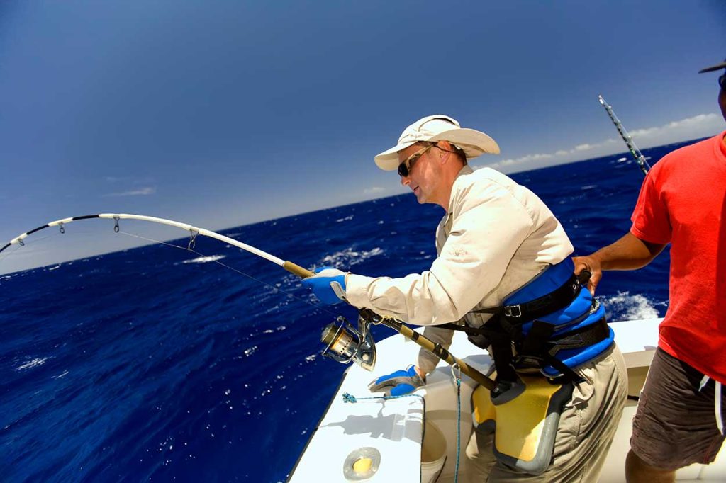 Angler using all his strength while fishing a fish.