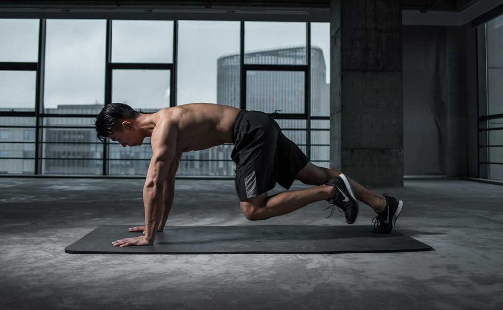 A man doing mountain climbers in the gym