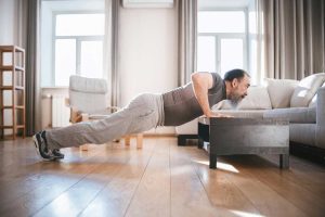 A man doing a push-up in his living room