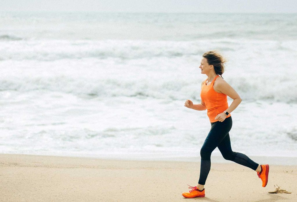 A female athlete running on the beach